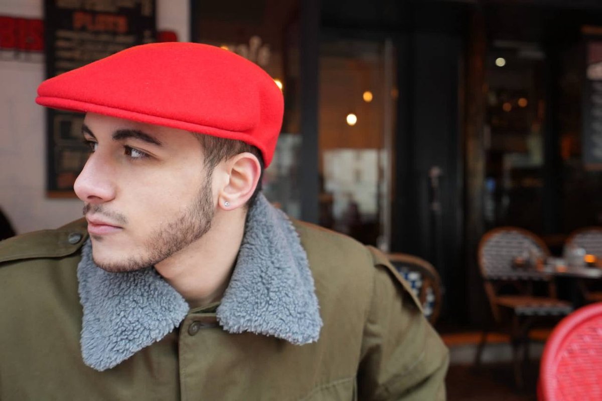 El Rayhan Loudhni en casquette rouge à la terrasse d'un café parisien