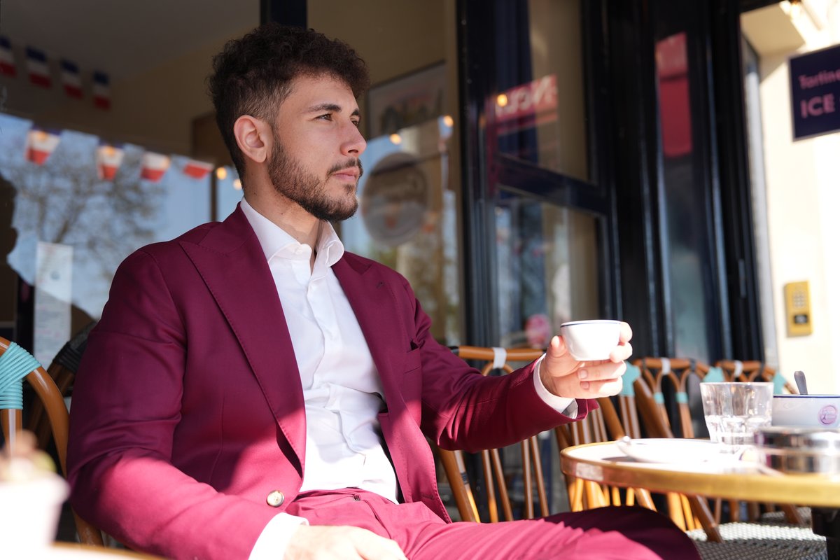 El Rayhan Loudhni en costume bordeaux dans un café parisien, lifestyle créateur de contenu